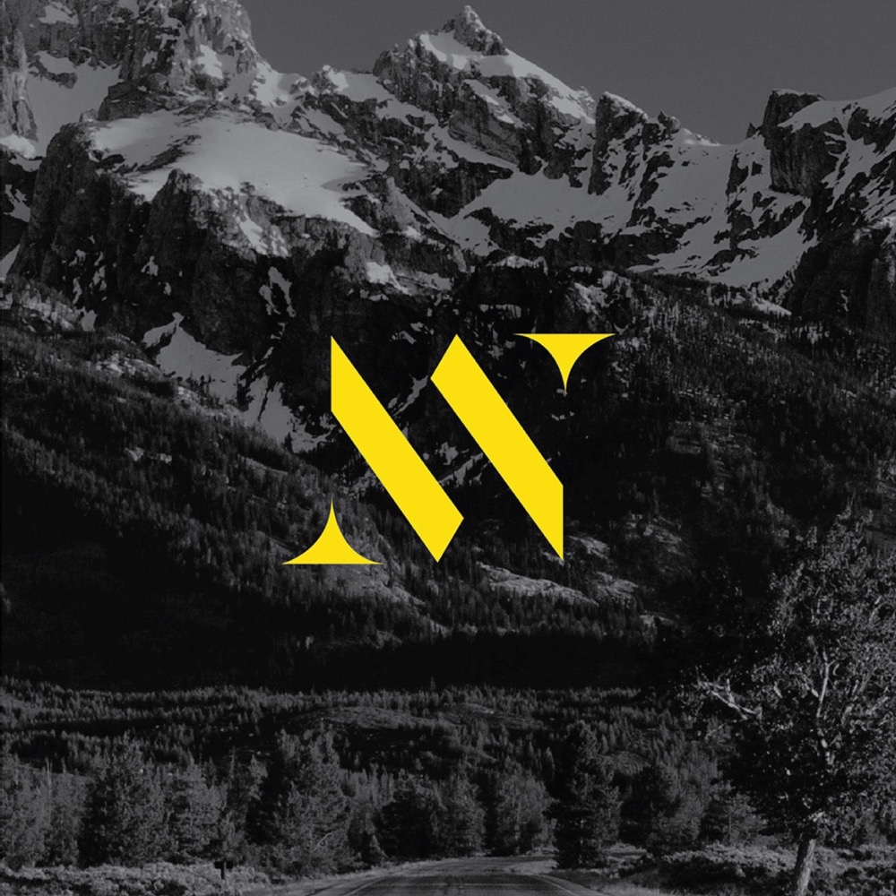 Yellow W logo over mountain landscape